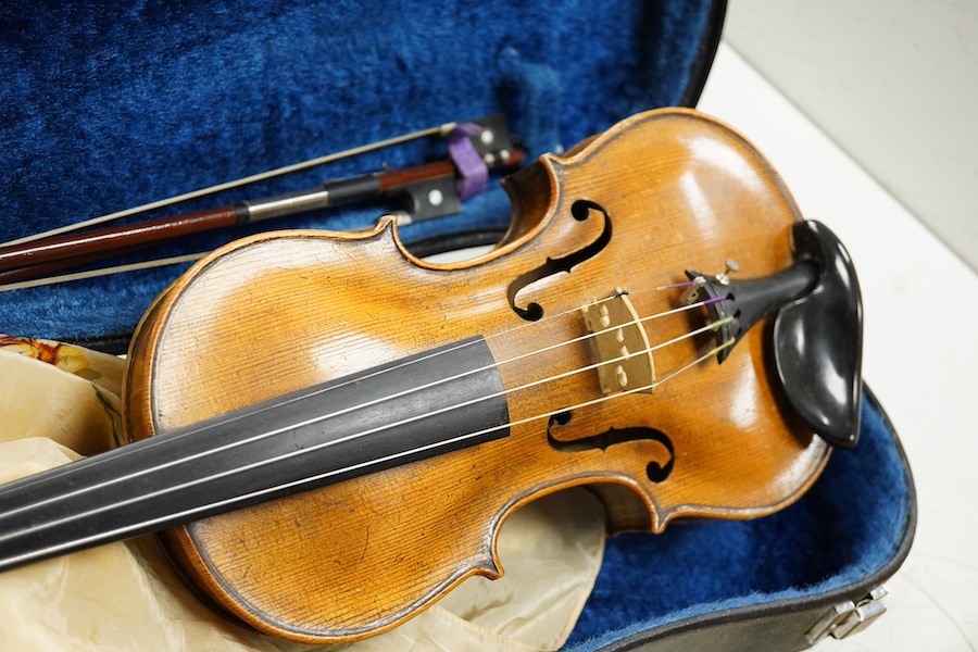 Four cased violins; an early 20th century violin, body 36cm, fitted with a microphone pick up taking a quarter inch jack plug, an early 20th century half size violin, body 32cm, and two student violins. Condition - poor